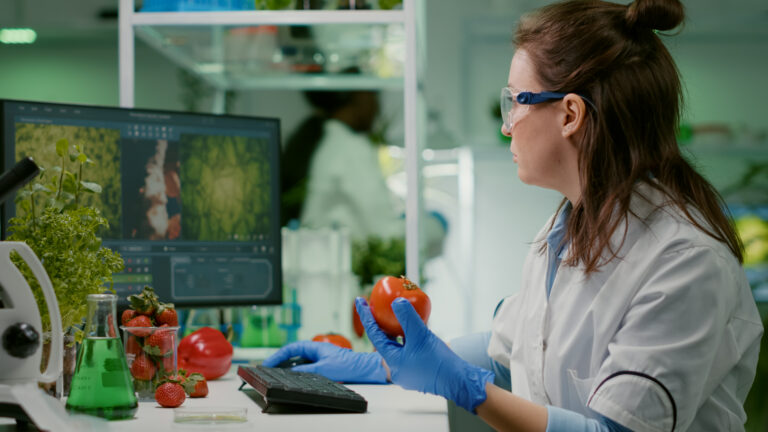 pharmaceutical-chemist-examining-tomato-microbiology-experiment-typing-medical-information